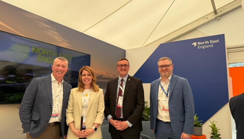 Panelists at UKREiiF posing on the North East England stage after investment prospectus launch. They are all smiling to camera.